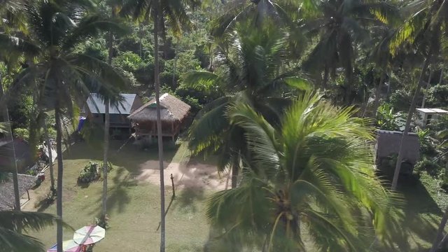Moving from right to left you can see backpacker palapas through the palm trees in the morning light on Koh Tonsai, Rabbit Island, Cambodia. Continuation from prior clip.