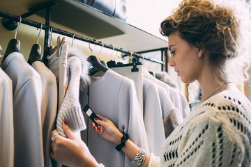 Young woman in a clothes store checking the price on the label