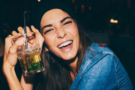 Portrait of a funny girl in a bar enjoying a mojito