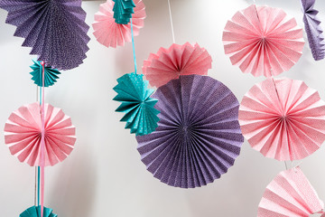 Origami fans wheel - paper craft folding and hanging against white wall