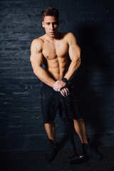 Fototapeta na wymiar portrait of a young physically fit man workout at gym with hammer. muscular athletic .