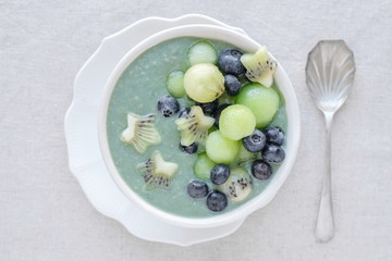 Blue spirulina smoothie bowl with melon, kiwi fruit and blueberries