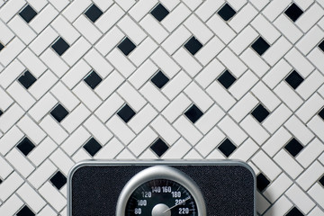 A bathroom scale found on a tiled floor