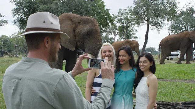  Friends on vacation in Africa pose for photo at wild elephant nature reserve