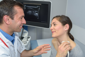 Doctor performing ultrasound on patient's neck