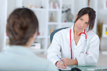 female doctor listening to her patientin office