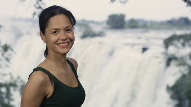Portrait smiling woman on African vacation with Victoria Falls in background