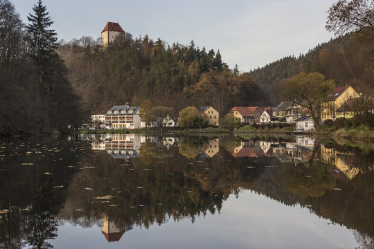 Ziegenrueck, Thuringia, Germany - small town reflected in river Saale in late fall