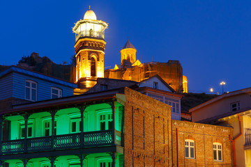 Amazing View of Jumah Mosque, Sulphur Baths and famous colorful balconies in old historic district Abanotubani in night Illumination during morning blue hour, Tbilisi, Georgia.