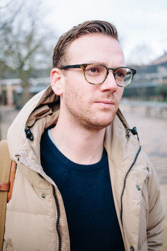 Portrait of a young man with glasses on a cold autumn day