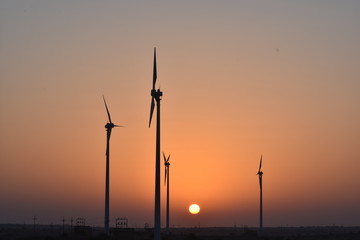 Obraz premium sunrise with modern windmills in thar desert india