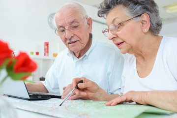 Couple looking at map and laptop