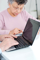 Naklejka premium mature couple sitting together with laptop