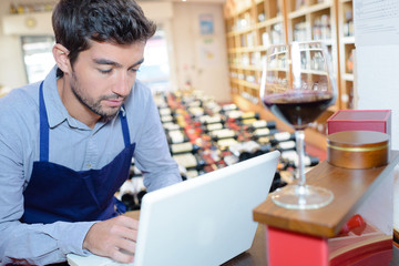 wine store seller using a laptop