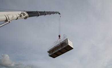 Industrial Crane operating and lifting an Cooling machine sunlight