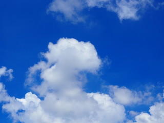 Clear bright blue sky with big white clouds, with grey shadow background, with big chunks coming from below frame border