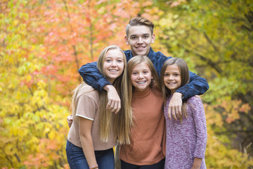 Beautiful Portrait of smiling happy teen kids outdoors. Four siblings standing together for a cute...