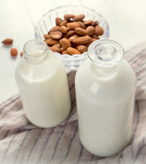 Almond milk in bottle with almonds
