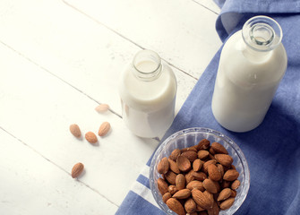 Almond milk in bottle with almonds