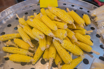 pile yellow corn boil in the market .