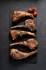 grilled lamb steak  and tomatoes on a black background.Top view.