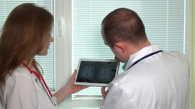 doctors looking at head mrt magnetic resonance imaging in tablet computer