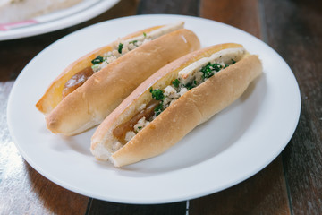 Vietnam Bread stuffed with Chinese sausage and pork on white plate.