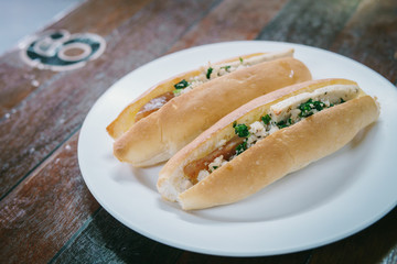 Vietnam Bread stuffed with Chinese sausage and pork on white plate.