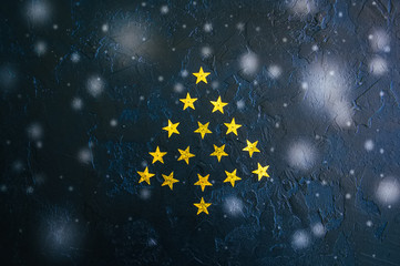 Christmas tree from golden stars over black stone background. Toned. Copy space.