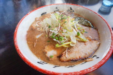Japanese ramen soup with pork on dark wooden background