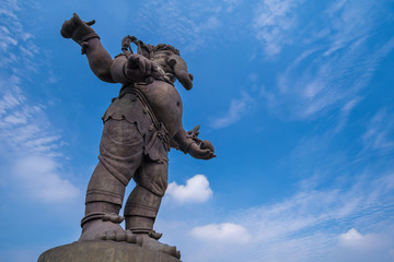 Lord Ganesha standing action statue with blue sky background - Powered by Adobe