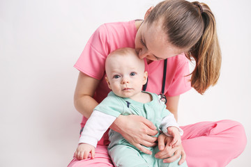 Nurse mother holding her baby dressed up in scrubs