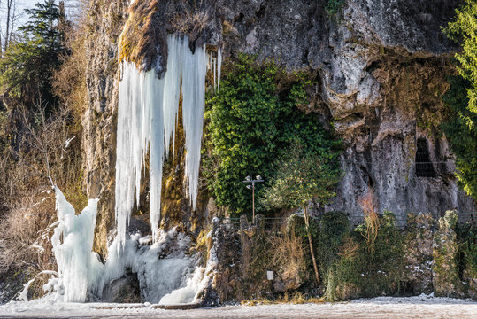 Ice waterfall. Wonders of nature. Natural winter attraction in northern Italy. Valganna Caves of karstic origin, tourist destination in the province of Varese