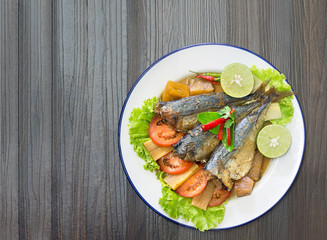 Mackerel boiled sweet and salted on white dish Thai food on old wooden table