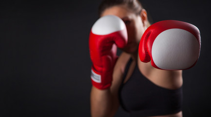 Female boxer with the red boxing gloves, black background with copy space