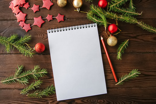 Empty white page of spiral notebook and christmas decoration on a wooden background. Flat lay.