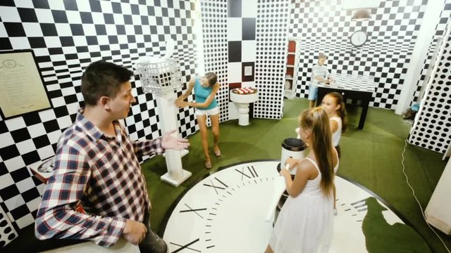 Parents with their children are visiting the escape room stylized under chessboard
