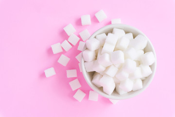 Fototapeta na wymiar Closeup sugar cubes on bowl with pink background