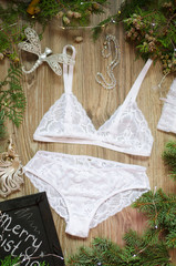 Bridal Christmas lace lingerie set. White bra and panties set on the Christmas festive background.