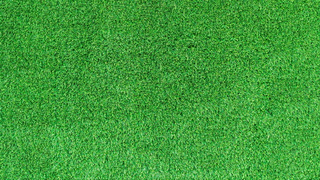 Artificial green grass texture or green grass background for golf course. soccer field or sports background concept design.
