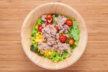 Tuna salad in bowl on wooden table.