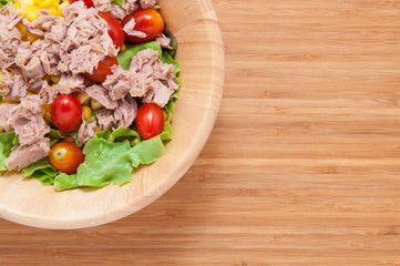 Tuna salad in bowl on wooden table.
