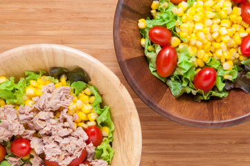 Tuna salad and Corn salad on wooden table.