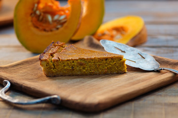 pumpkin pie  and fresh pumpkin on rustic wooden background