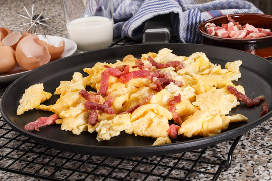 scrambled eggs with bacon in a pan