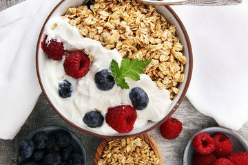 Bowl of homemade granola with yogurt and fresh berries