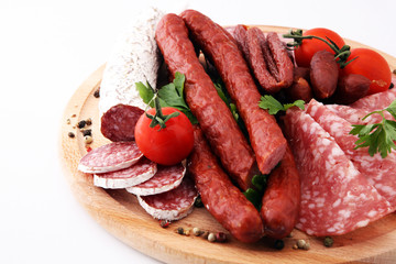 Food tray with delicious salami, pieces of sliced ham, sausage, tomatoes, salad and vegetable - Meat platter with selection - Cutting sausage and cured meat