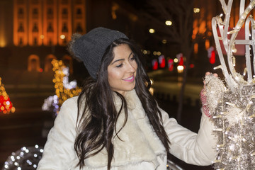 Beautiful smiling young woman  on a New Year's Eve.Night scene with lights