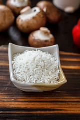 Ceramic bowl with the rice on wooden board.