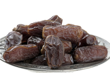 Dried dates in vintage plate isolated on white background.   